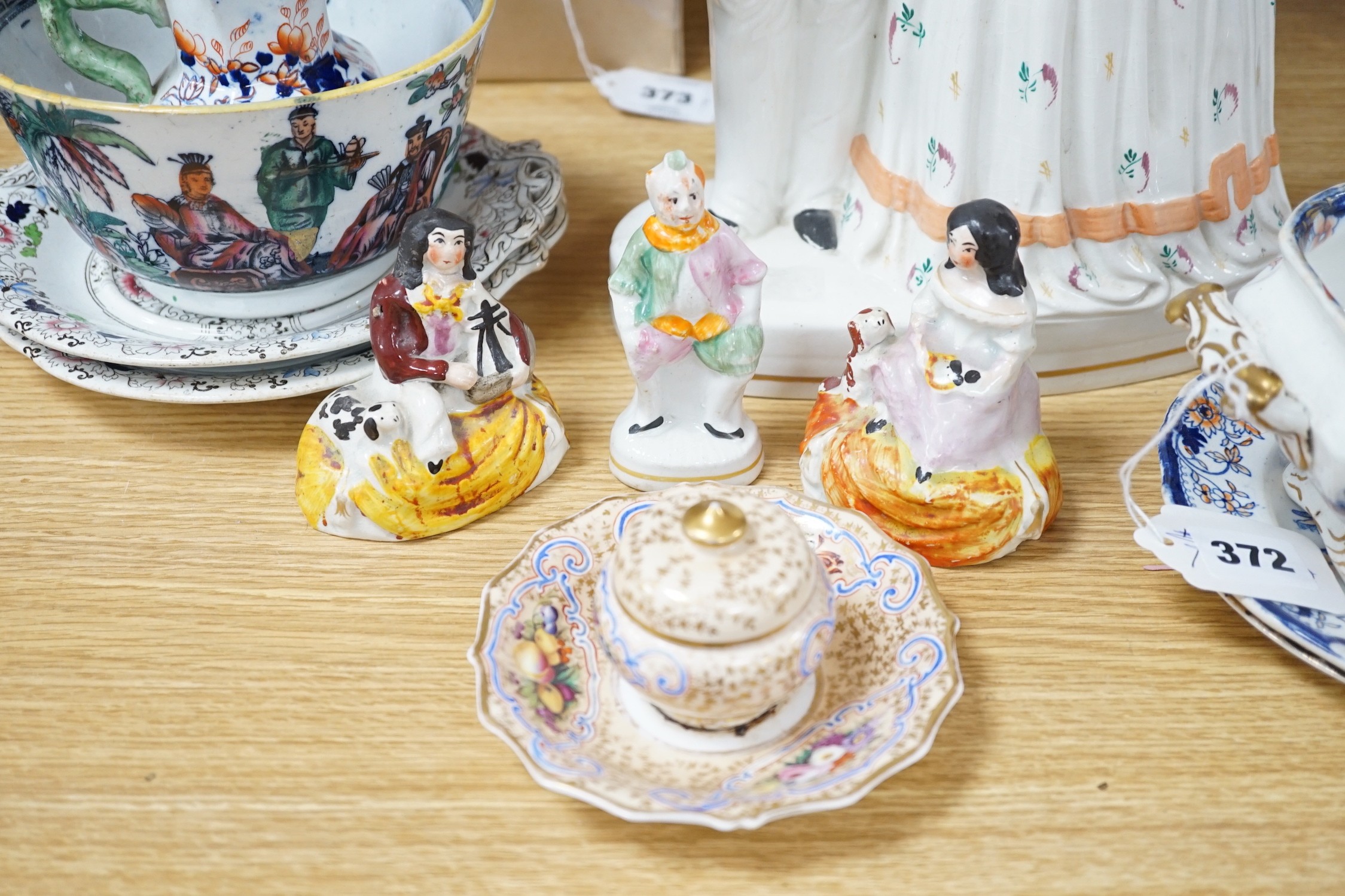 A pair of Staffordshire porcellaneous groups of children with a King Charles spaniel and a figure of Grimaldi the clown, c.1830-50 (3). Provenance - Dennis G. Rice collection. Together with other mixed ceramics